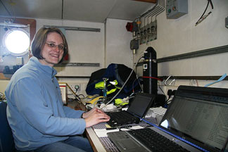 Evelyn configuring the bench-top FRR fluorometer (the black upright tube in the background) for the next photosynthesis measurement