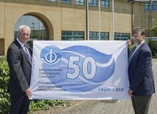 Trevor Guymer, head of the UK-IOC office presents a 50th anniversary flag to Robin Plumley, Research Ship Manager