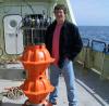 Professor Hughes onboard ship with an ocean bottom pressure recorder ready to launch